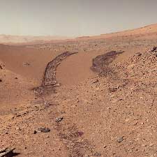 Curiosity rover looks back at the Martian dune it has just crossed.