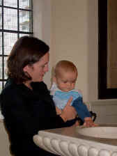 A mother and baby looking at the font before baptism